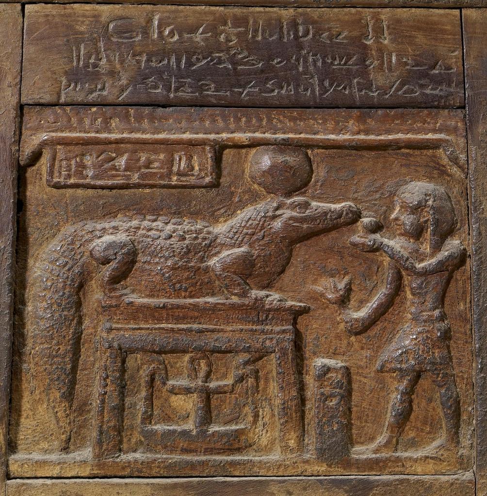 上图：主前1世纪的埃及盒子，描绘一位国王向鳄鱼神索贝克（Sobek）献祭，现藏于沃特斯艺术博物馆（Walters Art Museum）。索贝克是尼罗鳄与西非鳄的象征，常以鳄鱼或鳄头人身的形式现身。象征法老的王权、丰饶、生育与战争实力，也作为辟邪魔法的守护神。尼罗河鳄（Nile crocodile），是一种大型鳄鱼，非洲最大的爬行动物，体型仅次于河口鳄。尼罗鳄非常强壮，成年尼罗鳄的体重可以重达一吨。，平均寿命达70至100年。