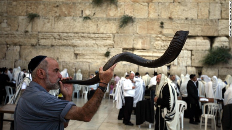 上图:一个犹太人于犹太新年在西墙吹响公羊角制成的羊角号(shofar)。犹太人被掳巴比伦回归以后,吹角节成为犹太人的农历新年(Rosh Hashanah),这一天要一百次吹响羊角号。