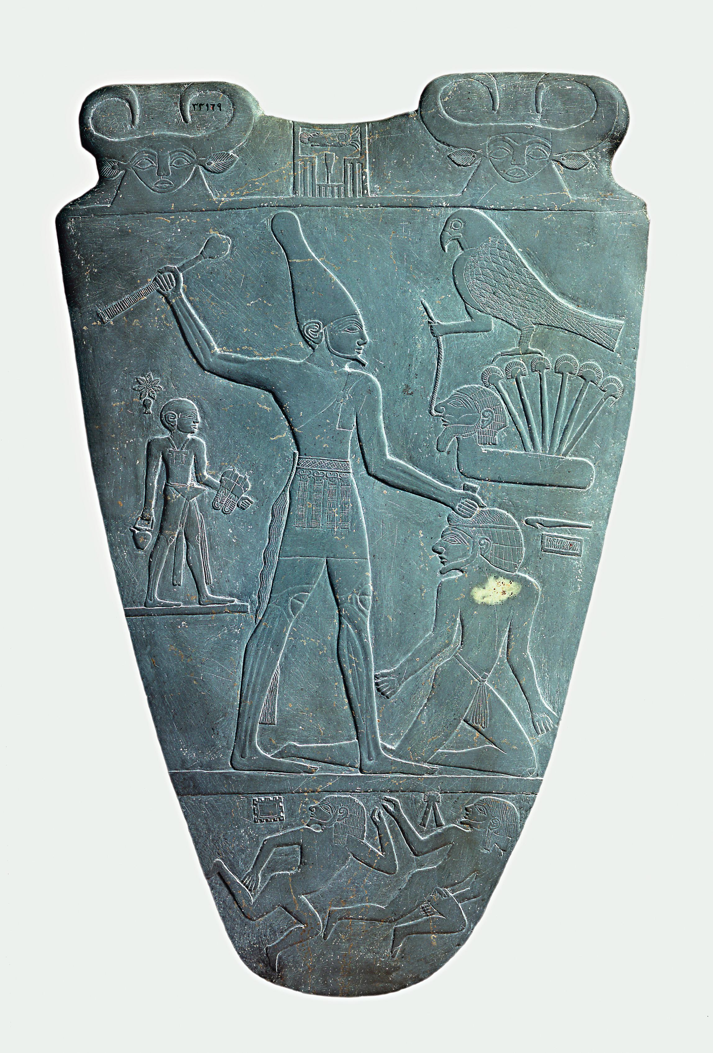 上图:主前31世纪的纳美尔石版(Narmer Palette)的正面,描绘统一了上下埃及的纳美尔头戴上埃及王冠,正要用权杖打破敌人的头,这个姿势后来成为埃及表现征服者的经典艺术形象。纳美尔石版是一个双面盾形的浮雕石板,一面描述戴着上埃及王冠的纳美尔,另一面描绘了戴着下埃及王冠的纳美尔,现藏于埃及开罗博物馆。