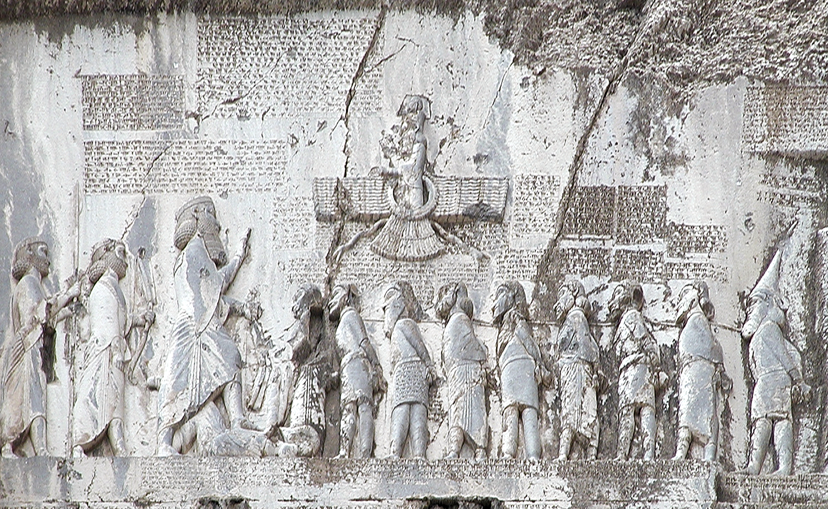 上图:贝希斯敦铭文(Behistun Inscription)是刻在伊朗贝希斯敦山崖上的多语言铭文,由波斯阿契美尼德帝国大流士一世所立,记录了他镇压高墨达(Gaumata)政变和各地反叛、取得王位的经过。石刻上有描绘大流士一世脚踏高墨达的浮雕,周围的铭文以三种不同的楔形文字写成:古波斯语、亚兰语和巴比伦语。这个石刻有如罗塞塔石碑之于埃及象形文字一样,极大地帮助了专家们破解楔形文字。1835年,英国人罗林森(Sir Henry Rawlinson)拓取了石刻上的古波斯文铭文,1844年又拓取了其余的铭文。在他和其他学者的努力下,古波斯文铭文首先被成功解读,其它两种铭文随后也被成功解读。