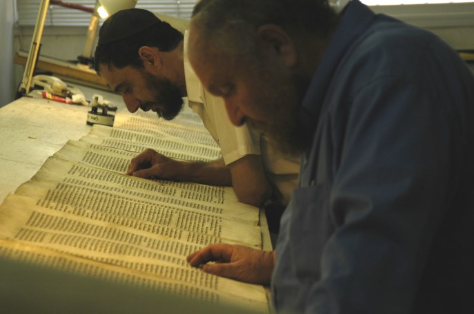 上图：两位耶路撒冷的文士正在校对妥拉经卷（Torah Scroll）。希伯来圣经抄写员被称为文士（Sofer/Sofrim），意思是「字母数算者」。神拣选了一批敬虔、严谨的文士把摩西五经（妥拉）抄传了3500年，在304,805个字母中，只有6个不太重要的字母存在疑问。文士必须遵守超过4000条犹太律法，每个笔画什幺地方粗、什幺地方细，什幺字母必须变大、什幺字母必须变小，什幺字母必须添加单顶皇冠，什幺字母必须添加三顶皇冠，都有具体规定。因此，只有最虔诚的正统犹太人才有资格做文士，他们抄写妥拉就像建造会幕一样认真。