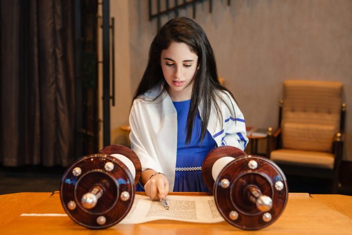 上图:一个犹太女孩在成为「诫命之女 Bat Mitzvah」的成人礼上诵读经文,她的身上披着祷告巾( Tallit)。犹太教女孩到了12岁,在律法上就和成年人有同样的权利和义务,被称为「诫命之女」。犹太女孩在成人礼之前,由父母在神面前为自己的行为负责,而在成人礼之后,必须自己向神负责。因此,只有「诫命之女」,才可以「向耶和华许愿,要约束自己」(民三十3)。