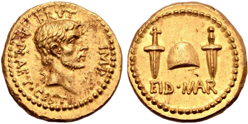 上图：主前42年秋天，布鲁图斯（Brutus）在腓立比即将战败之前发行的金币，庆祝元老院于主前44年3月15日三月节（Ides of March）刺杀凯撒。正面是自称「我爱凯撒，我更爱罗马」的布鲁图斯，背面写着「在三月节」的缩写EID MAR（Eidibus Martiis – on the Ides of March） ，中间是两把匕首之间的自由帽（Cap of Freedom）。自由帽是罗马奴隶被释放时传统戴着的帽子，但刀剑所带来的自由并没有长久，罗马共和国经过多年内战，于主前27年变成了专制独裁的罗马帝国。