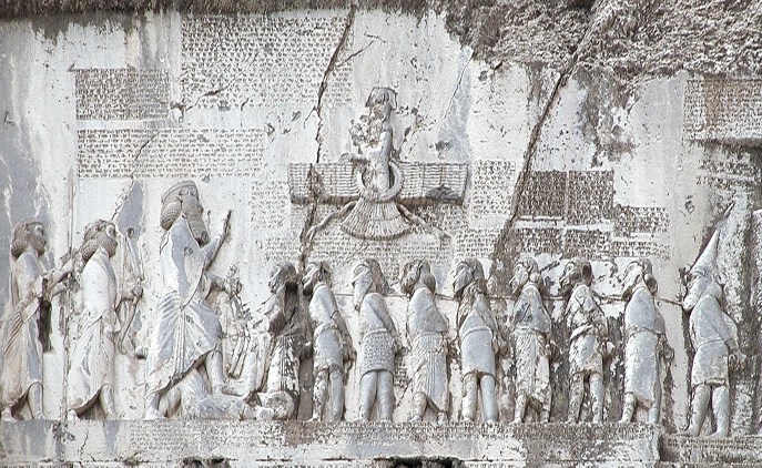 上图：贝希斯敦铭文（Behistun Inscription）是刻在伊朗贝希斯敦山崖上的多语言铭文，由波斯阿契美尼德帝国大流士一世所立，记录了他镇压高墨达（Gaumata）政变和各地反叛、取得王位的经过。石刻上有描绘大流士一世脚踏高墨达的浮雕，周围的铭文以三种不同的楔形文字写成：古波斯语、亚兰语和巴比伦语。这个石刻有如罗塞塔石碑之于埃及象形文字一样，极大地帮助了专家们破解楔形文字。1835年，英国人罗林森（Sir Henry Rawlinson）拓取了石刻上的古波斯文铭文，1844年又拓取了其余的铭文。在他和其他学者的努力下，古波斯文铭文首先被成功解读，其它两种铭文随后也被成功解读。